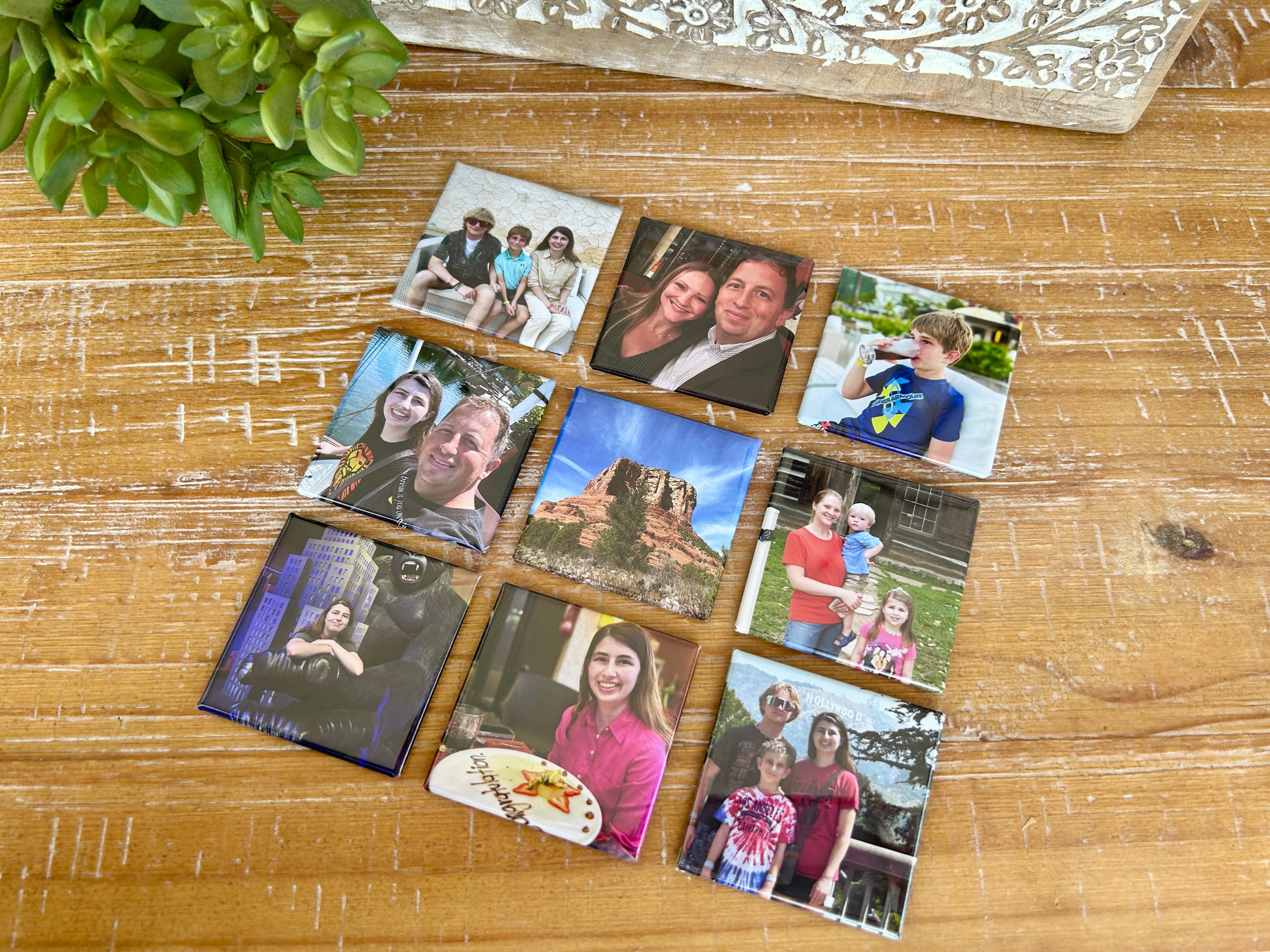 9 photo magnets laid out on a table in a grid pattern.
